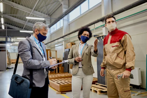 Quality control inspectors talking male worker while visiting woodworking factory coronavirus pandemic 11857